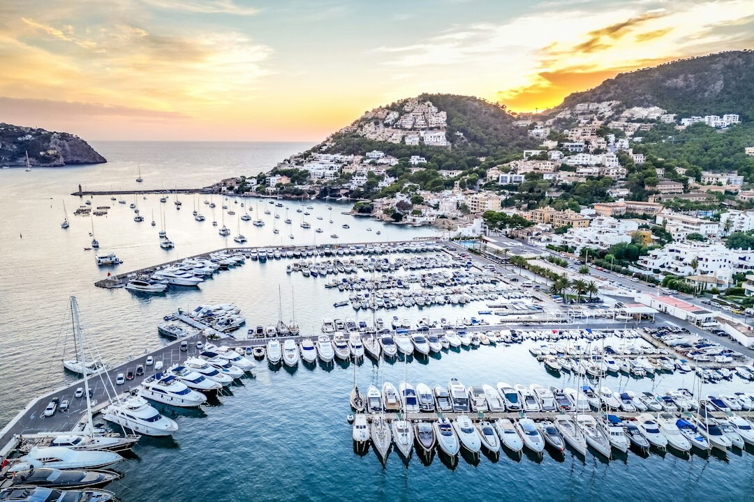 Luxury yacht docked near a coastal resort at sunset